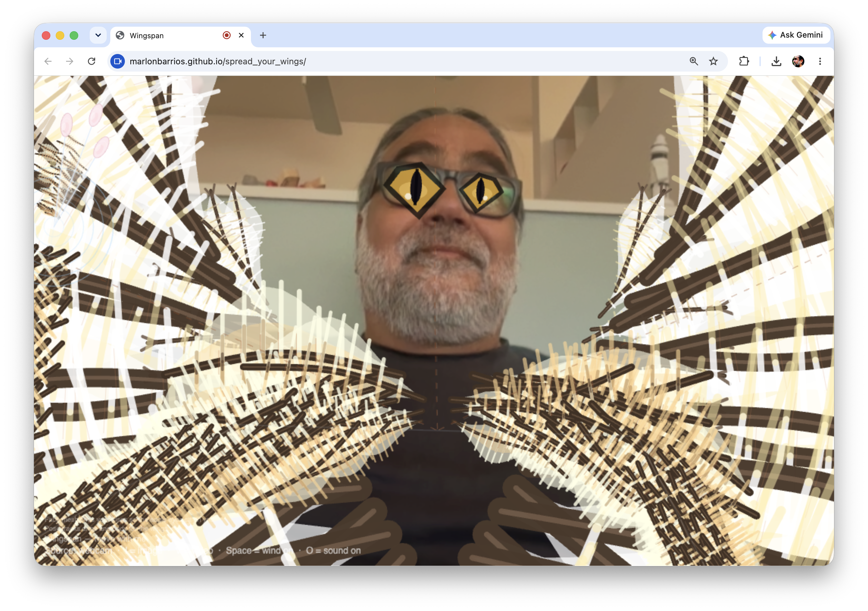 Wingspan: webcam portrait with yellow animal-like eyes and branching wing overlays across the chest.