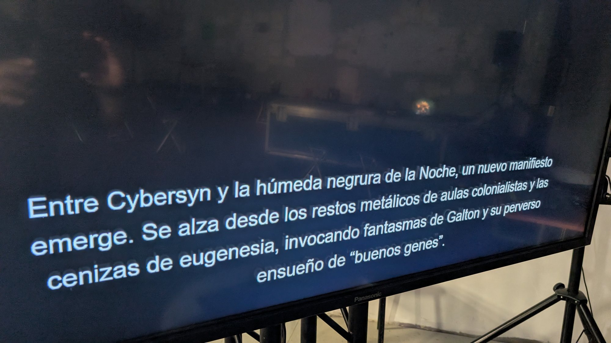A screen in the installation showing a Spanish text that begins Entre Cybersyn y la húmeda negrura de la Noche.