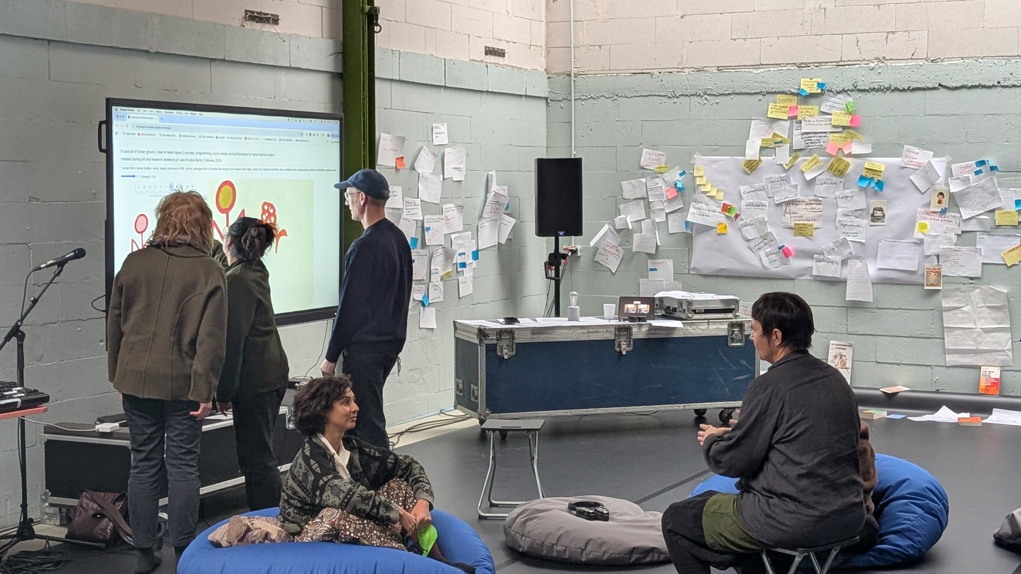 Participants gathered around a projected score, with notes covering the studio wall, at Beyond Gravity Festival, 2025.